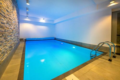 a swimming pool in a room with a brick wall at Moselromantik Hotel Kessler Meyer in Cochem