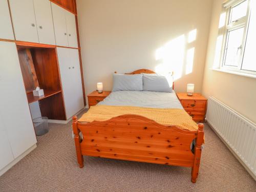 Un dormitorio con una cama de madera con dos velas. en Mullagh Road, en Miltown Malbay