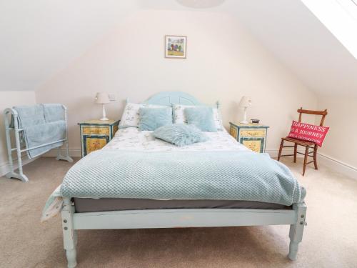 1 dormitorio con 1 cama, 2 mesas y 1 silla en Lynchpin Cottage, en Bruff
