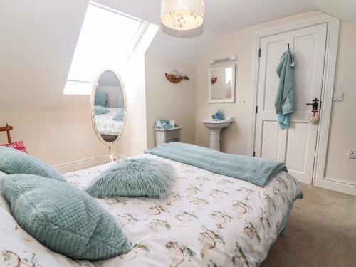 um quarto com uma cama, um espelho e uma janela em Lynchpin Cottage em Bruff