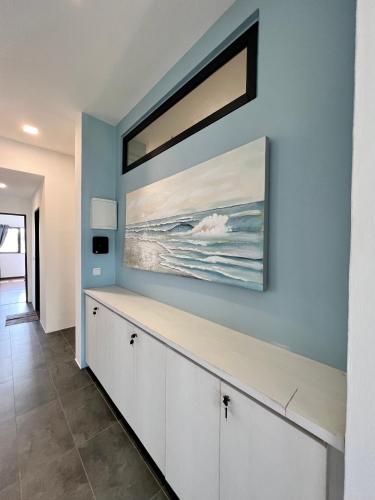 a living room with a painting on the wall at Roxy Sematan Beach Townhouse Deluxe 7 ,8 ,9, 10 ,11 ,12 in Sematan