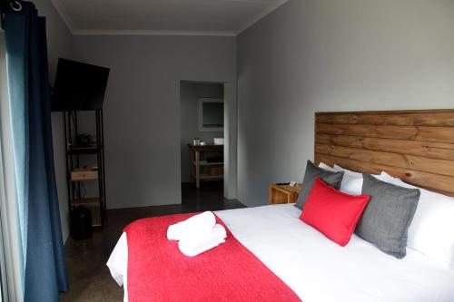 - une chambre dotée d'un grand lit avec des oreillers rouges et gris dans l'établissement Zero90, à Swellendam