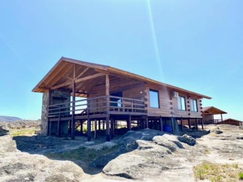 a large wooden house on top of a mountain at Alma Serrana - Suites de montaña! in La Cumbrecita