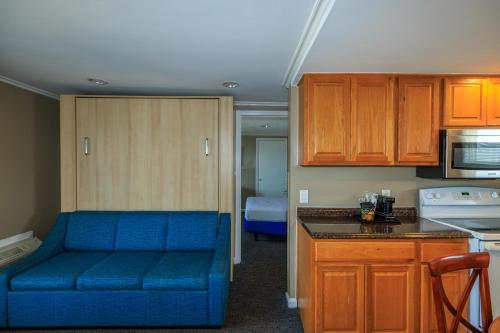 a living room with a blue couch in a kitchen at The White Sands Resort and Spa in Point Pleasant Beach