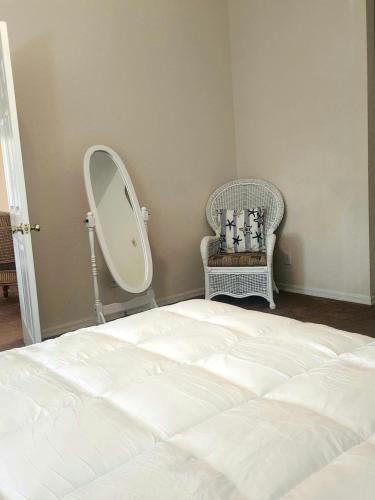 1 dormitorio con cama, espejo y silla en Bahama Bay 116 en Kissimmee