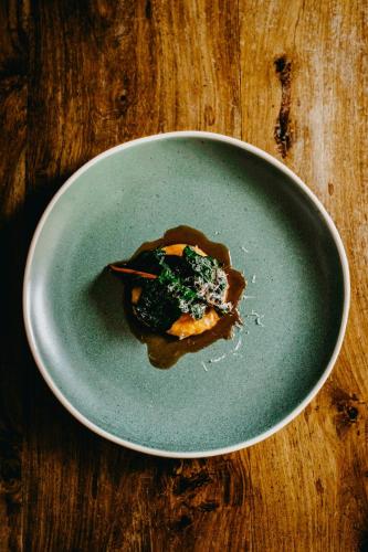 a blue plate of food on a wooden table at Coorie Inn Restaurant and Rooms in Crieff