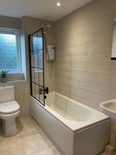 a bathroom with a tub and a toilet and a sink at 2 bed city centre modern flat in Edinburgh