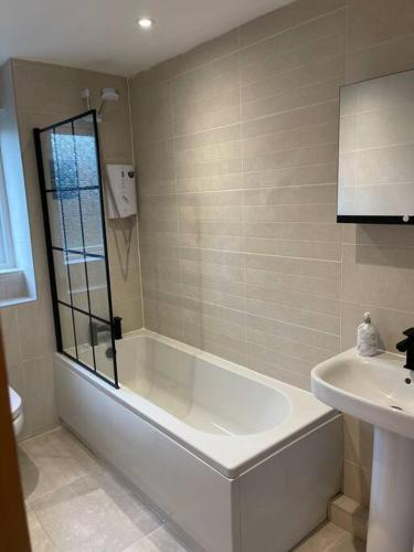 a bathroom with a bath tub and a sink at 2 bed city centre modern flat in Edinburgh