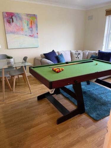 un soggiorno con tavolo da biliardo e divano di 2 bed city centre modern flat a Edimburgo