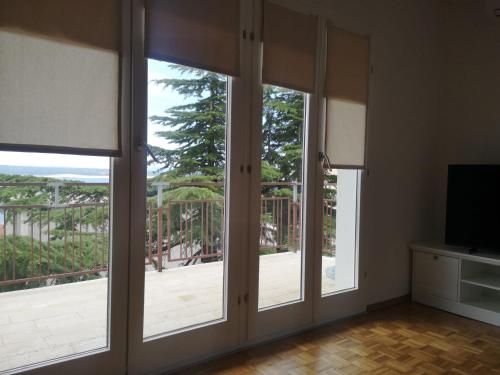 a room with sliding glass doors with a view of a deck at Apartments Netty in Dramalj
