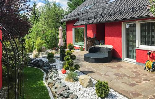 a backyard with a red house and a rock garden at Amazing Apartment In Schauenstein With Wifi in Schauenstein