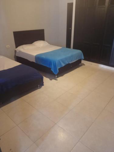 two beds in a room with a tile floor at Comfort inn in Maicao