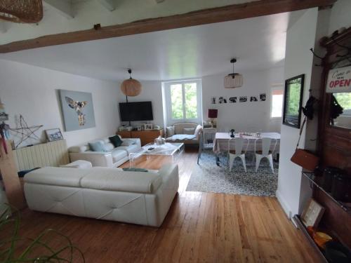 a living room with a white couch and a table at Maison d'hôtes Larraldia in Uhart-Cize