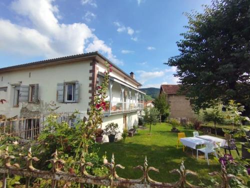 a house with a garden and a table in the yard at Maison d'hôtes Larraldia in Uhart-Cize