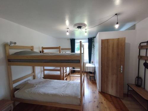 a room with two bunk beds and a door at Maison d'hôtes Larraldia in Uhart-Cize