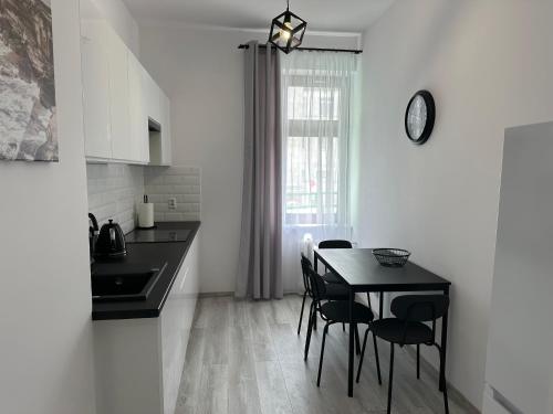 a kitchen with a black table and chairs in a room at Apartamenty Przy Deptaku in Świnoujście