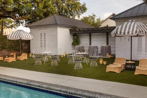 a backyard with chairs and tables and a pool at Kimpton Brice Hotel by IHG in Savannah
