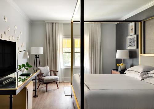 Dormitorio con cama, escritorio y TV en Kimpton Brice Hotel, an IHG Hotel en Savannah