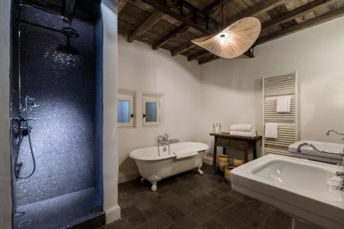 y baño con bañera, lavamanos y ducha. en Les Petites Maisons - Hameau des Baux, en Paradou