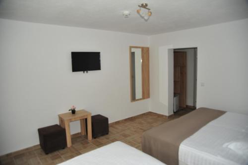 a bedroom with two beds and a television on the wall at Hotel Ancora in Eforie Sud