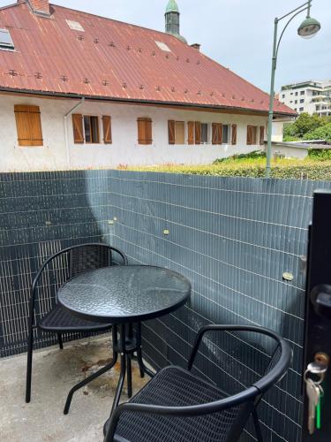 a table and two chairs sitting next to a wall at « Petit Paris » - T2 centre ville Parking/balcon in Albertville
