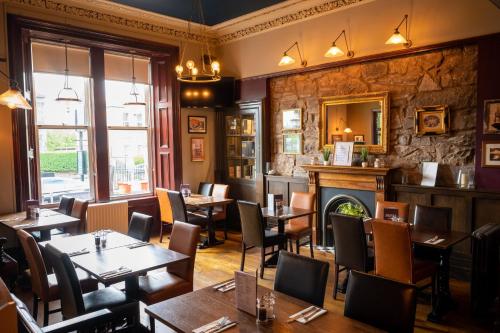 a restaurant with tables and chairs and a fireplace at Edinburgh Whisky House Hotel in Edinburgh