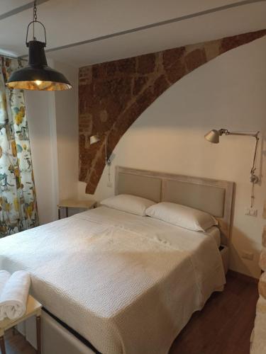 a bedroom with a bed with a stone wall at BB Orvieto in Orvieto