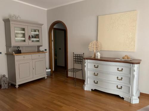 Habitación con armarios blancos y cómoda. en Home53, en Arezzo