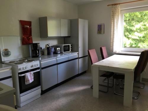 a kitchen with a table and a stove and a table and chairs at Ferienwohnung Graupner in Schwarzenberg