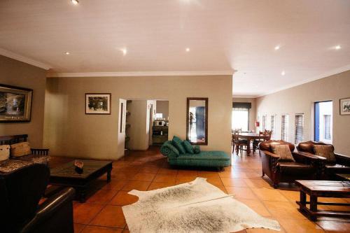 a living room with a couch and chairs and a table at The Nutcracker Homestead in Venterskroon
