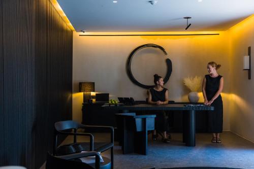 two women standing in front of a desk in a room at Noima Boutique Hotel Mykonos in Agios Ioannis Mykonos
