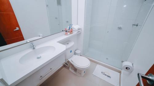 ein Badezimmer mit einem Waschbecken, einem WC und einem Spiegel in der Unterkunft Hotel Seven Monteria in Montería