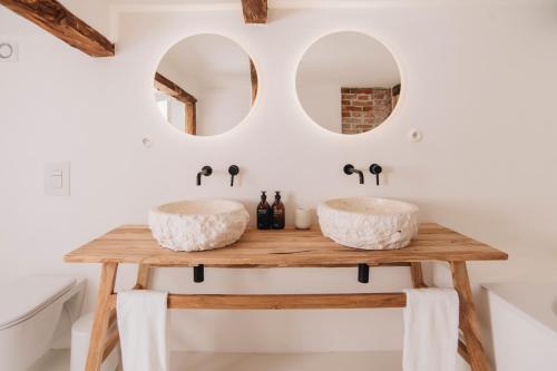 Dois lavatórios numa mesa de madeira numa casa de banho com espelhos em V Bezovém Údolí em Kryštofovo Údolí