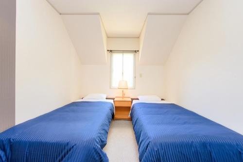 two blue beds in a room with a window at TABIHAKU STAY Hakusan - Vacation STAY 37435v in Shirakawa