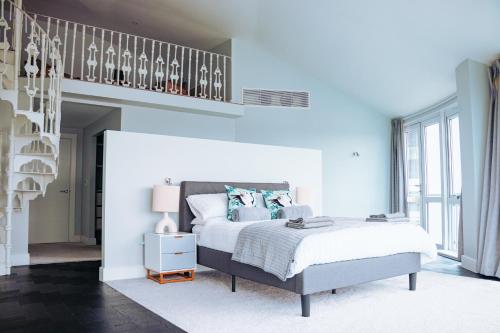 a bedroom with a king sized bed and a staircase at Luxury Three-Bedroom Penthouse- By Resify in Nottingham