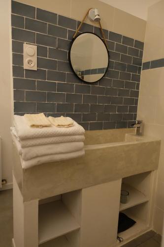 Mirandol-Bourgnounac的住宿－La maison Cayré，浴室配有带镜子的盥洗盆和毛巾