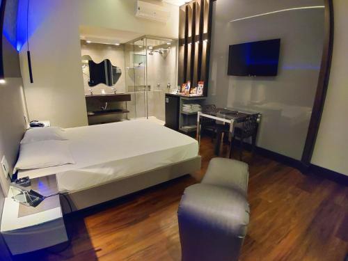 a bedroom with a bed and a desk and a mirror at Motel Dallas in Belo Horizonte