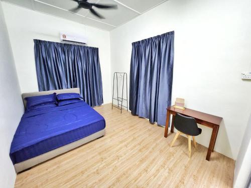 a bedroom with a blue bed and a desk at Happy Vacation Homestay Mersing 2 in Mersing