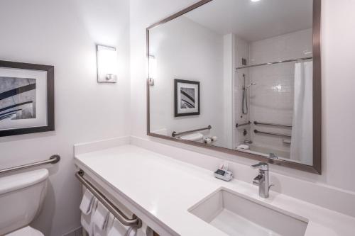 Aloft San Jose Cupertino في سان خوسيه: حمام أبيض مع حوض ومرآة