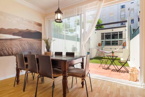 a dining room with a table and chairs and a large window at Nesha Guesthouse Lisbon in Lisbon