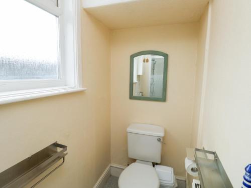 La salle de bains est pourvue de toilettes et d'une fenêtre. dans l'établissement Flat 2, à Teignmouth