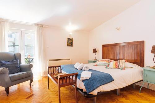 ein Schlafzimmer mit einem großen Bett und einem Stuhl in der Unterkunft Nesha Guesthouse Lisbon in Lissabon
