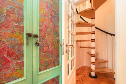 a spiral staircase in a room with colorful wallpaper at Nesha Guesthouse Lisbon in Lisbon