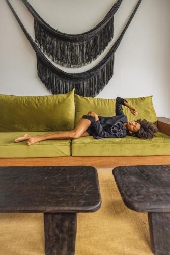 a woman laying on a couch in a living room at KA BRU 1100 Boutique Hotel in Taipu