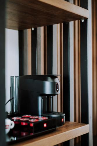 a black coffee maker sitting on a wooden shelf at LAN-GO SIVOTA Luxury Living in Sivota