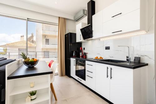 a kitchen with white cabinets and black countertops at Yin & Yang Studio, Marina Hideout in Kalamata (B3) in Kalamata