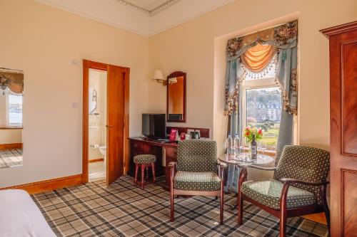 a room with a table and chairs and a window at Muthu Alexandra Hotel in Oban