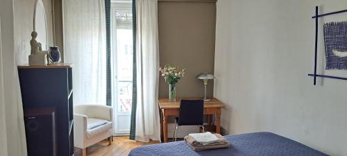 a bedroom with a bed and a desk with a vase of flowers at vue sur Rhône in Lyon