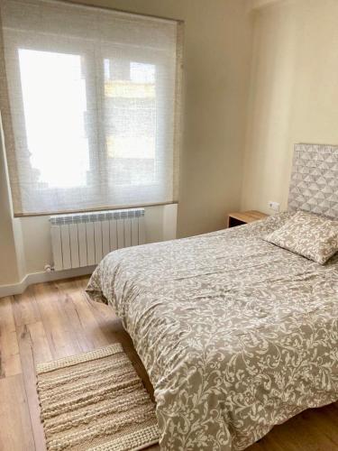 a bedroom with a large bed and a window at Soleado - En el centro de Gijón in Gijón