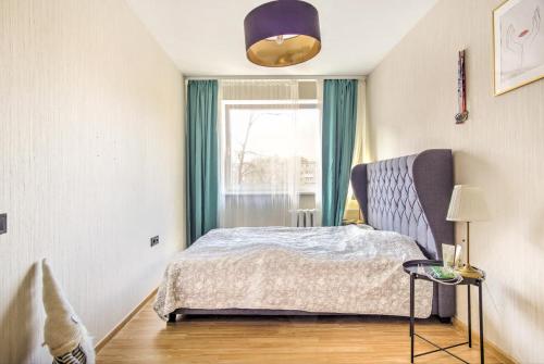 een slaapkamer met een bed en een raam bij Cozy flat near city center and airport. FREE PARKING in Vilnius